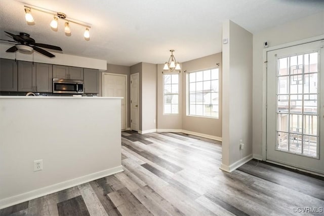 kitchen with pendant lighting, a textured ceiling, light wood-type flooring, ceiling fan, and gray cabinetry