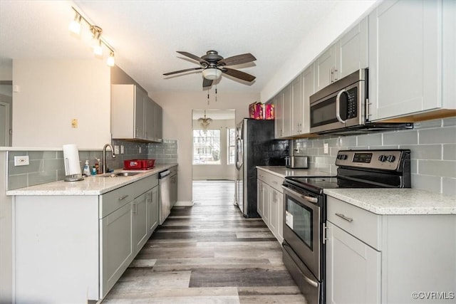 kitchen with light hardwood / wood-style flooring, ceiling fan, sink, gray cabinetry, and stainless steel appliances