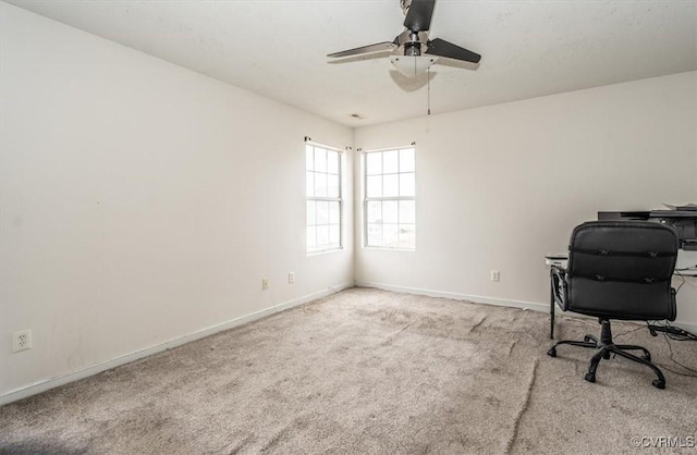 unfurnished office with ceiling fan and light carpet