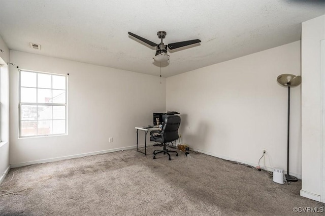 unfurnished office featuring light carpet and ceiling fan