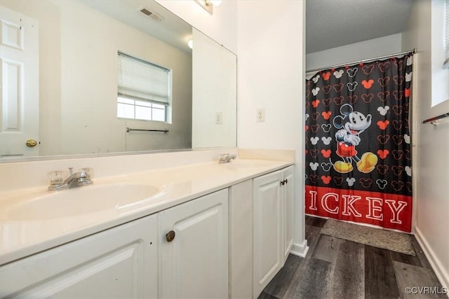 bathroom with hardwood / wood-style flooring, curtained shower, and vanity