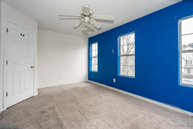 spare room featuring light carpet and ceiling fan