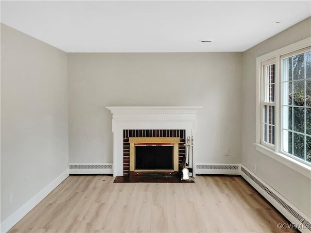 unfurnished living room with a brick fireplace, baseboard heating, and light hardwood / wood-style flooring