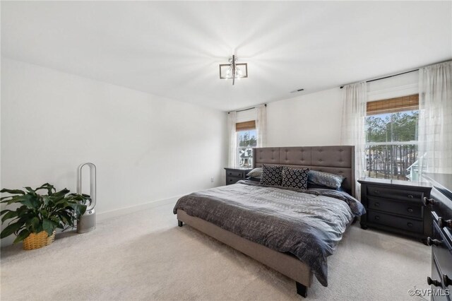 bedroom with baseboards and light colored carpet