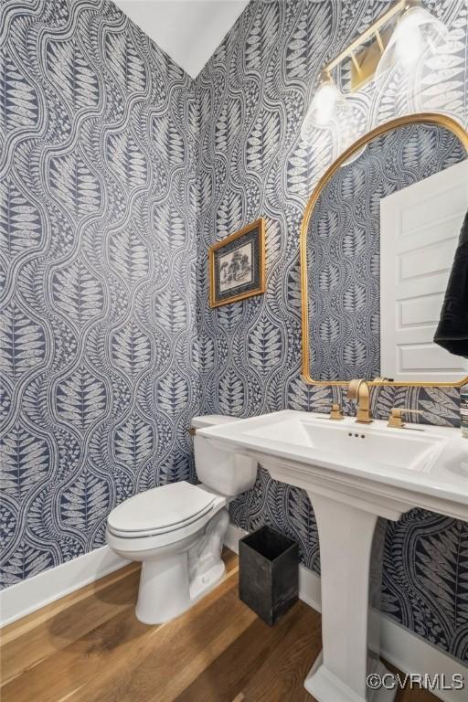 bathroom with toilet and wood finished floors