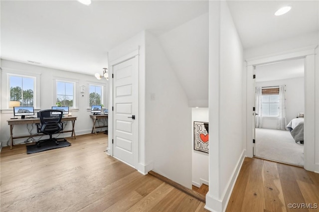 hall with light wood-style floors and baseboards