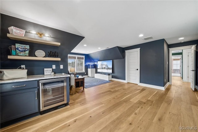 bar with wine cooler, visible vents, baseboards, light wood-type flooring, and a dry bar