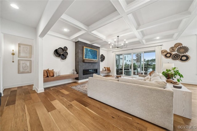 living room featuring beam ceiling, a tiled fireplace, and wood finished floors