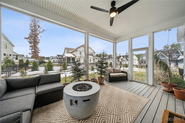 sunroom / solarium featuring ceiling fan and a residential view