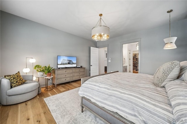 bedroom with wood finished floors and a notable chandelier