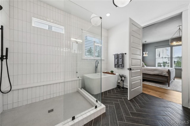 ensuite bathroom featuring connected bathroom, recessed lighting, parquet flooring, tiled shower, and a soaking tub