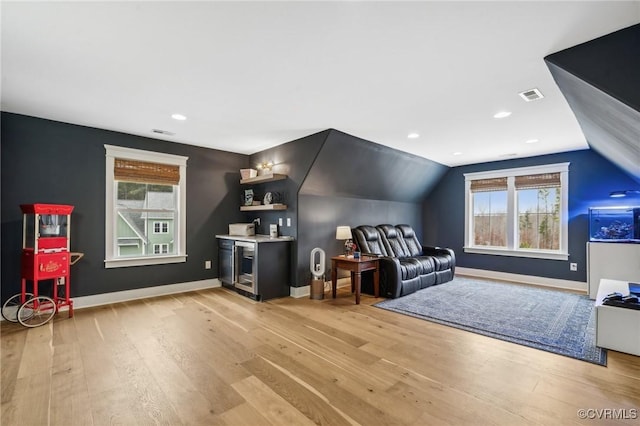 interior space featuring light wood finished floors, plenty of natural light, visible vents, and baseboards