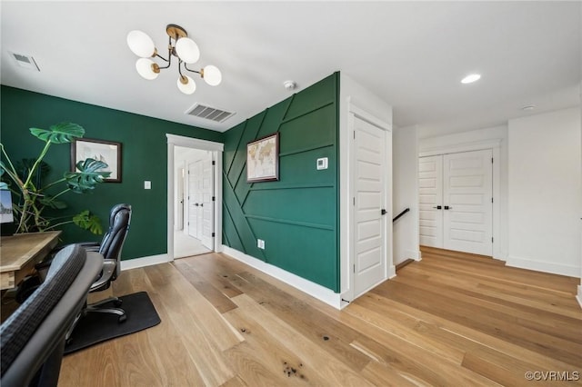 home office featuring light wood finished floors, visible vents, and baseboards