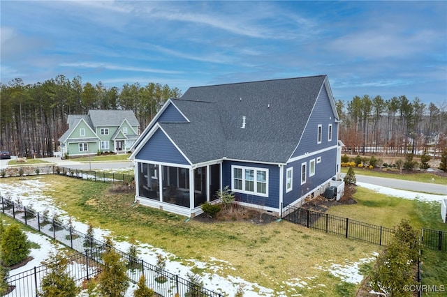 back of property featuring a sunroom, a yard, and central AC unit