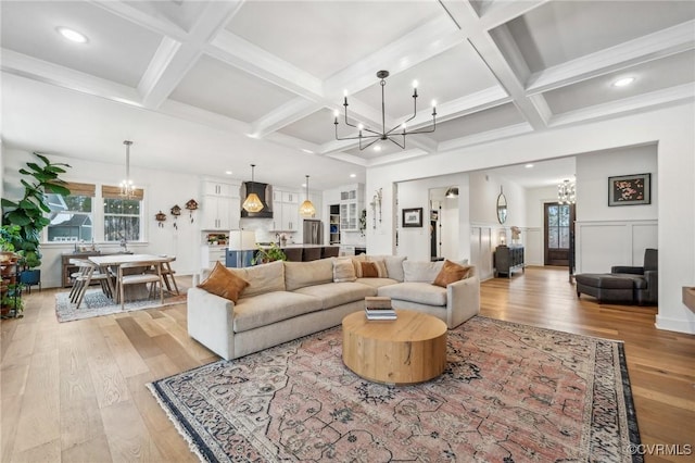 living area featuring an inviting chandelier, light wood finished floors, beamed ceiling, and coffered ceiling