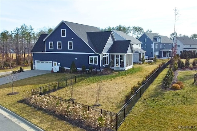 view of front of property featuring fence private yard, a residential view, driveway, and a front lawn