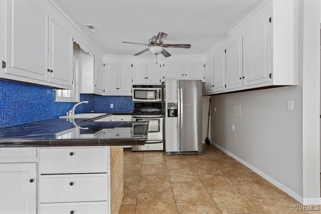 kitchen with sink, appliances with stainless steel finishes, white cabinetry, tile countertops, and kitchen peninsula