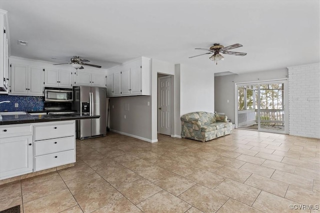 kitchen with white cabinetry, ceiling fan, appliances with stainless steel finishes, and decorative backsplash