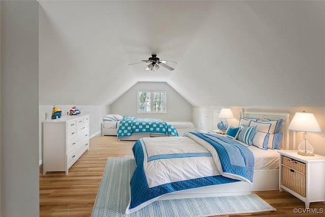 bedroom with light hardwood / wood-style flooring, ceiling fan, and vaulted ceiling