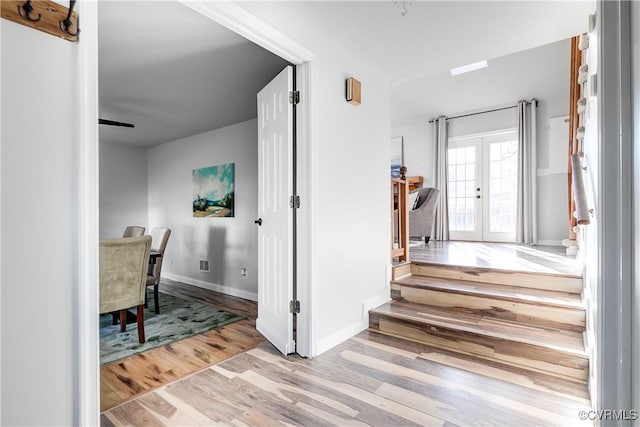 corridor featuring light hardwood / wood-style floors and french doors