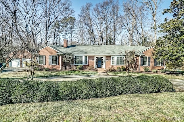 single story home featuring an outbuilding, a garage, and a front yard