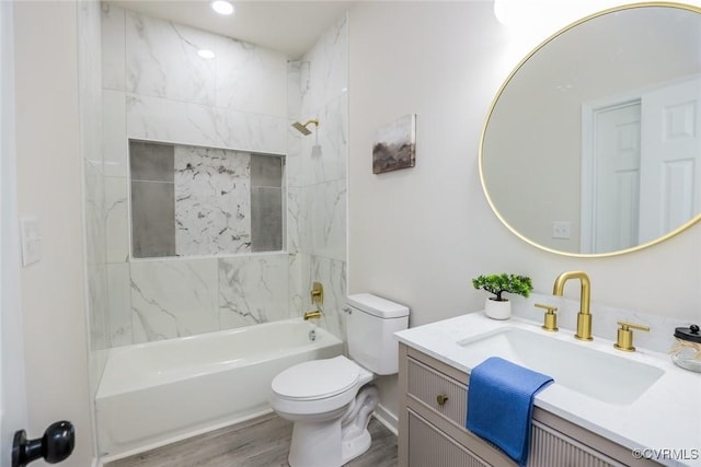 full bathroom featuring wood-type flooring, toilet, vanity, and tiled shower / bath