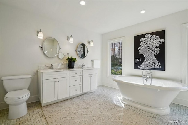 bathroom featuring a tub, toilet, and vanity