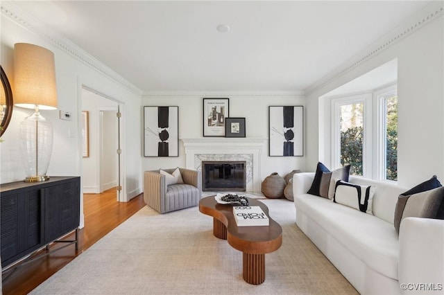 living room with crown molding, hardwood / wood-style flooring, and a premium fireplace