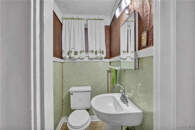 bathroom with toilet, sink, and a textured ceiling