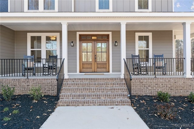 entrance to property featuring a porch and french doors