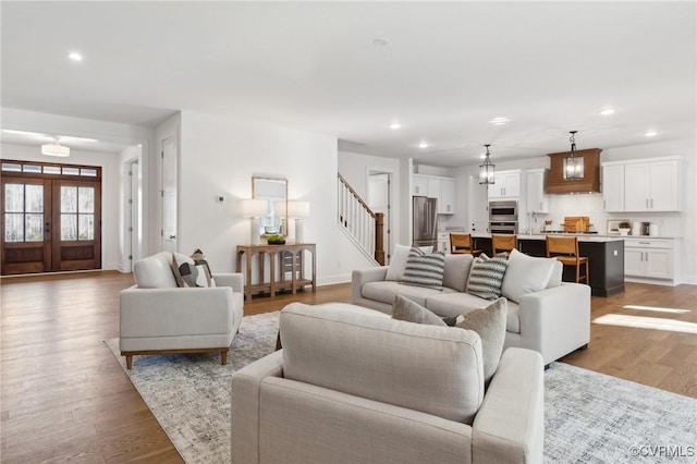 living room featuring light wood-type flooring, french doors, and sink