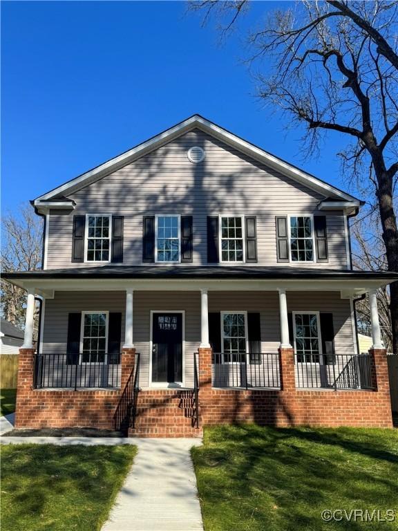 view of front of house with covered porch and a front yard