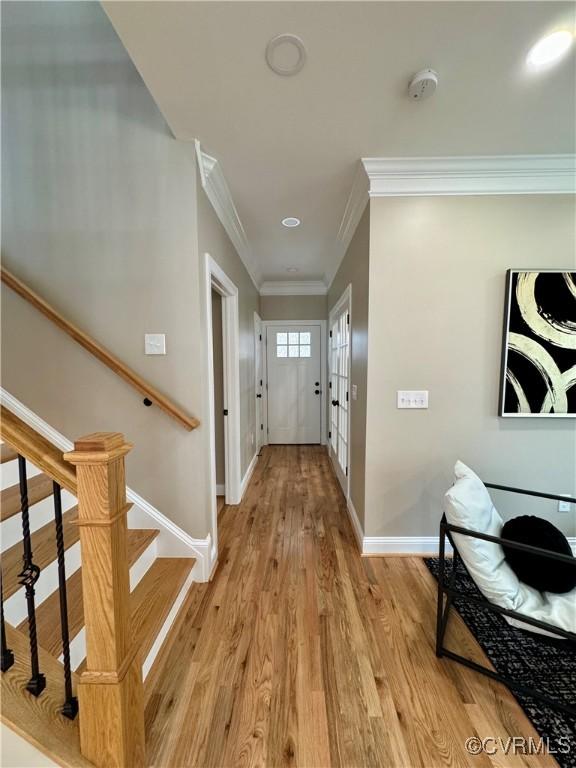 interior space with crown molding and light hardwood / wood-style floors