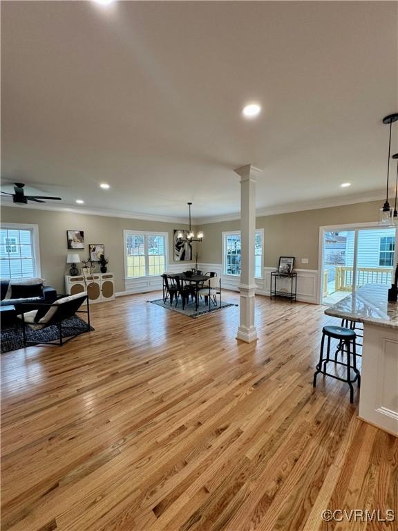 interior space featuring a wealth of natural light, light wood-style flooring, and ornate columns