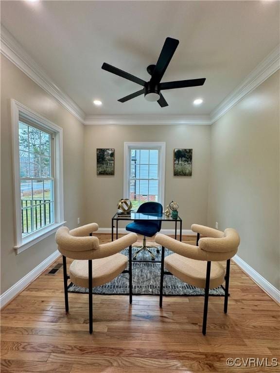 sitting room featuring light wood-style floors, a healthy amount of sunlight, visible vents, and crown molding