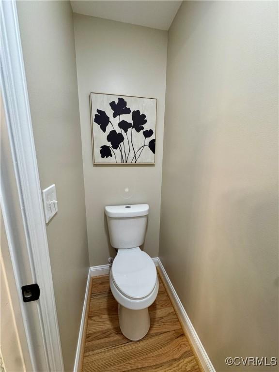 bathroom featuring baseboards, toilet, and wood finished floors