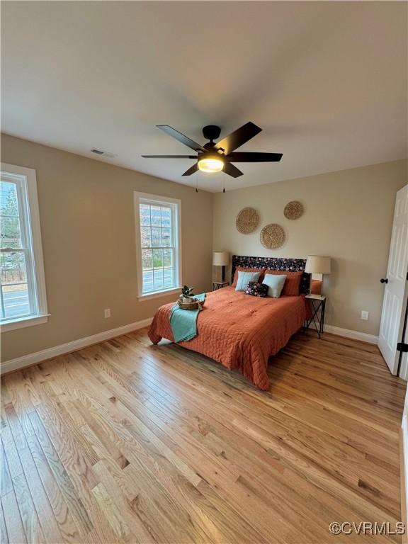 bedroom featuring a ceiling fan, baseboards, visible vents, and light wood finished floors