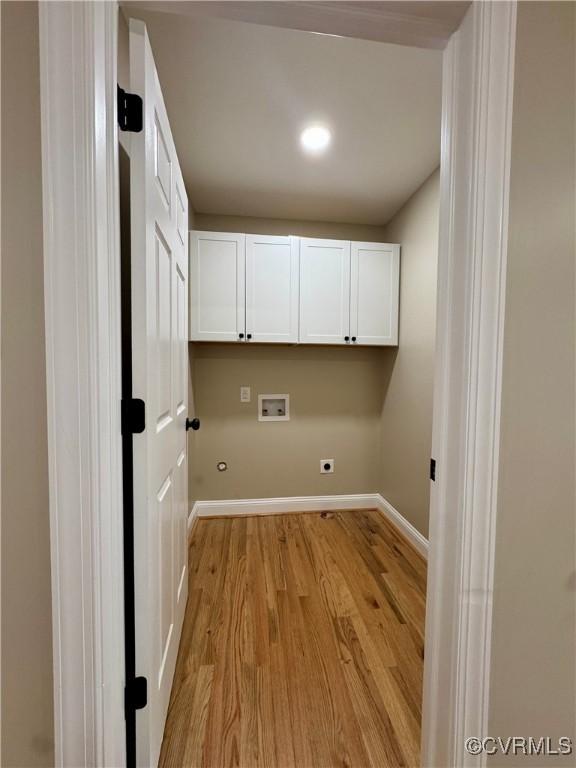 clothes washing area with hookup for a washing machine, hookup for an electric dryer, baseboards, light wood-style floors, and cabinet space