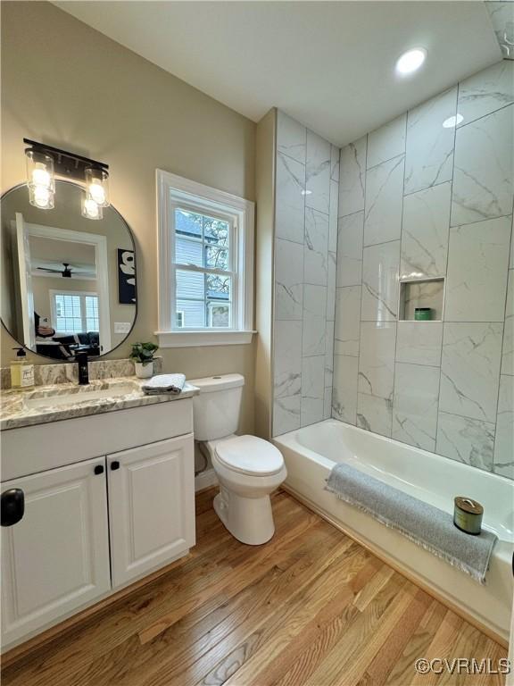 bathroom featuring bathtub / shower combination, vanity, toilet, and wood finished floors