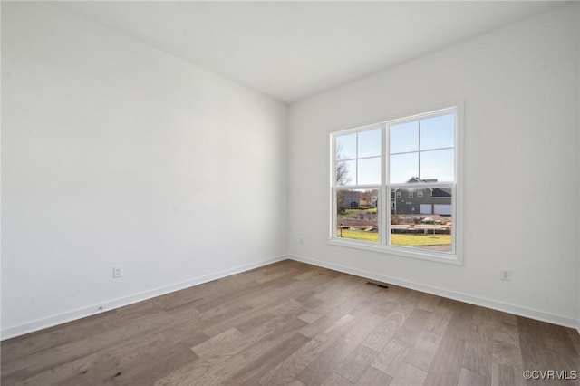 unfurnished room with hardwood / wood-style floors