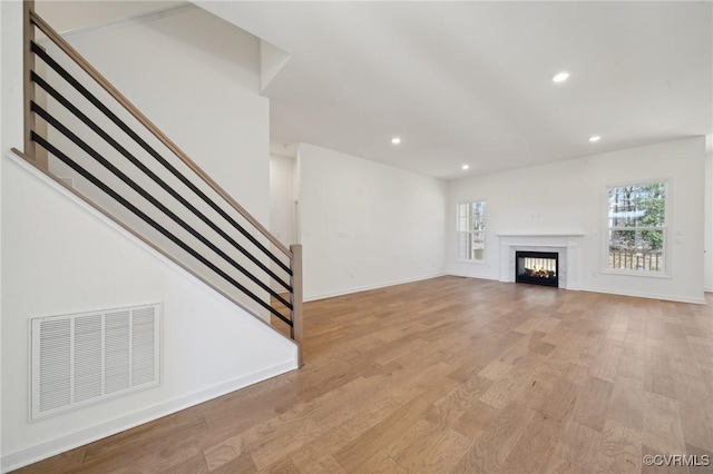 unfurnished living room featuring a wealth of natural light and light hardwood / wood-style flooring