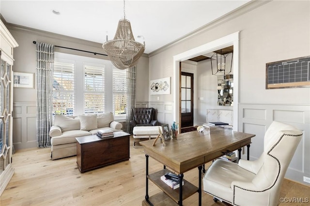 living room with ornamental molding, light hardwood / wood-style floors, and a chandelier