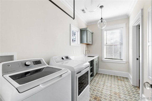 washroom featuring sink, ornamental molding, and washer and dryer