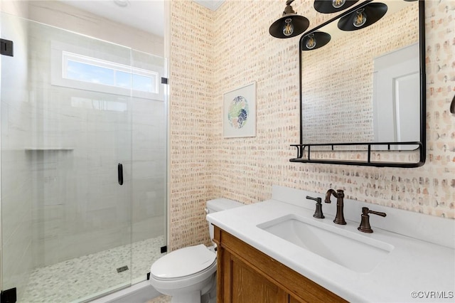 bathroom with vanity, a shower with shower door, and toilet