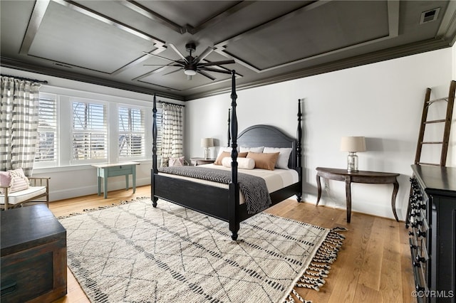 bedroom featuring ornamental molding, coffered ceiling, ceiling fan, and light wood-type flooring