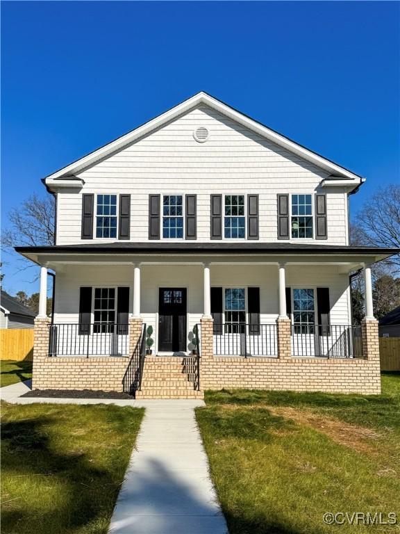 view of front of property with covered porch and a front lawn