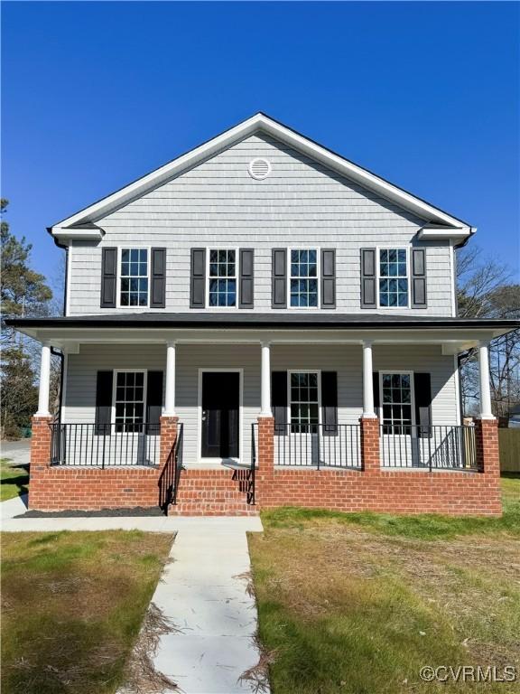 view of front of property with covered porch and a front lawn