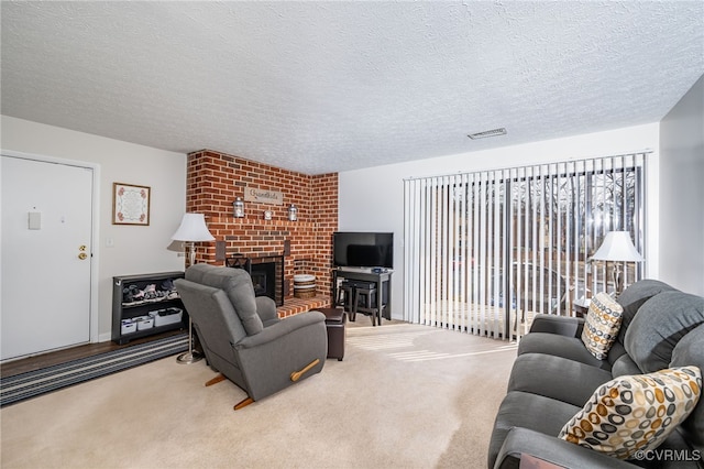 living room featuring carpet, a textured ceiling, and a fireplace