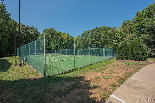 view of tennis court with a yard