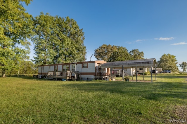 rear view of house featuring a deck, a lawn, and a carport